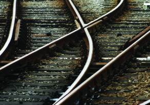 Close-up view of intersecting railway tracks with detailed focus on track switches and wooden sleepers, symbolizing organizational change.