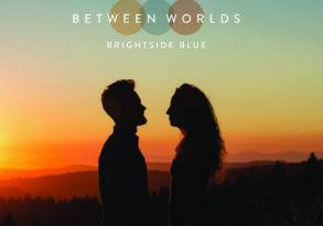 Silhouetted couple facing each other at sunset with rolling hills in the background, overlaid with the text "Worlds Between" and “brightside blue.”